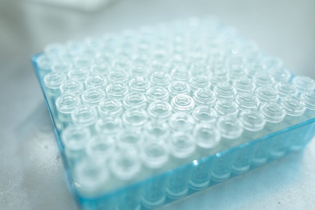 A detailed close-up of transparent glass vials arranged in a blue tray, ideal for scientific analysis.
